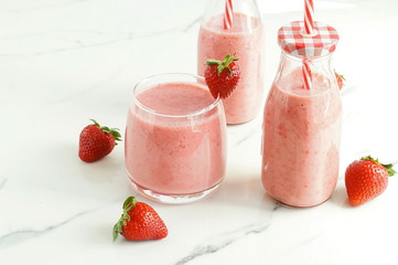 Strawberry smoothie or milkshake in a glass on marble background. Healthy food for breakfast and snack. copy space