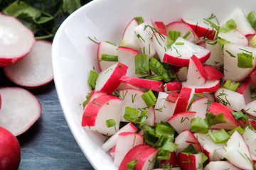 Salad of fresh radishes and fresh herbs on a blue wooden table. Spring vegetable salad. ingredients for cooking salad.
