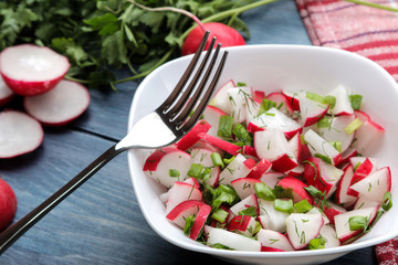 Salad of fresh radishes and fresh herbs on a blue wooden table. Spring vegetable salad. ingredients for cooking salad.