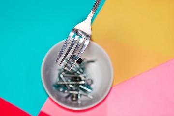 Bolts on the fork in the plate in the way of food on bright backgrounds