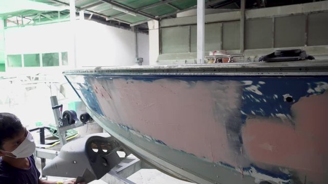 The mechanic repair the boat  , Using plastic putty ,Prepare surface for spray painting