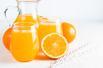 Close-up of a glass of orange juice with oranges fruits on wooden and stone background. Vitamins and minerals. Healthy drink and beverage concept.