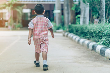 Back view of Boy followed girl friends on street to go to the classroom in school.