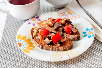 Vegetable stew with eggplant, red bell pepper and tomatoes on toasted rye bread
