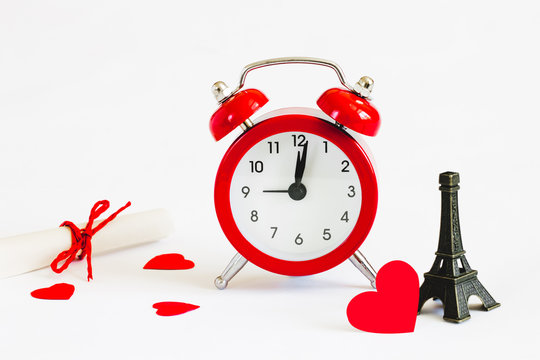 Romantic trip to Paris concept. Honeymoon, time to fall in love. Invitation to a romantic trip, a love note. Eiffel tower with red alarm clock
