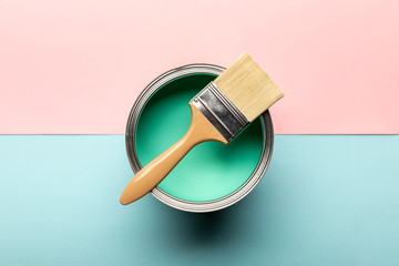 top view of can on green paint and brush on pink and blue surface