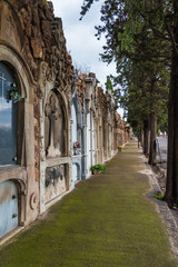 Perspective view of the footpath with graves on the Montjuic Cemetery in overcast day, Barcelona, Catalonia, Spain