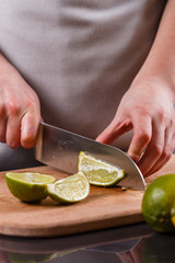 young woman in a gray aprons cut lime