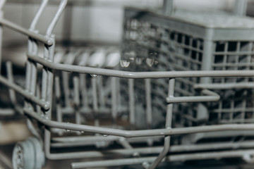 empty open dishwasher closeup. cutlery compartment close-up. household appliances in the kitchen macro