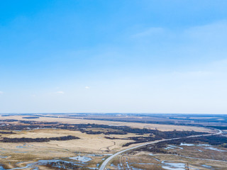 Aerial view of a marshland near a highway with an asphalt road during a spring flood, which floods...