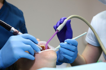 Macro photo of a patient on dental treatment in the dental office. The concept of health and beauty.