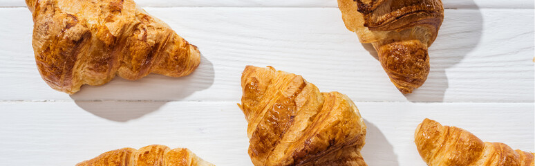 panoramic shot of tasty and sweet croissants on white surface