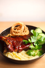 baked barbecue ribs with mashed potatoes in a cast iron pan