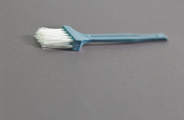 Small dusting brush For cleaning white bristles, green handles on a black background
