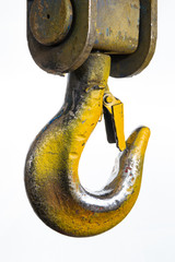 Closeup of a yellow lifting crane hook on a white background
