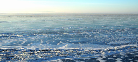 Naklejka na ściany i meble Sun rays are refracted by the transparent ice of Lake Baikal. crystal clear ice fragments — hummocks