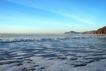 Naklejka na ściany i meble Sun rays are refracted by the transparent ice of Lake Baikal. crystal clear ice fragments — hummocks