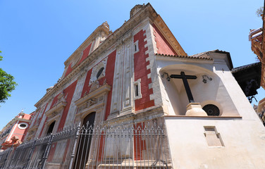 Fototapeta na wymiar Red facade of the Church of Saviour 1674-1712 at Plaza del Salvador , Seville, Spain. Architects Esteban Garcia and Leonardo de Figueroa.