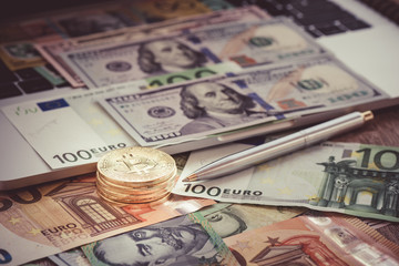 Fototapeta premium Closeup bitcoin with banknote and pen for business concept, Coin with euro and dollar banknote on keyboard for business online