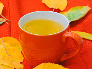 Cup of coffee, dry cracker cookies and dry leaves on an orange background. Autumn background, flat lay. Autumn composition. Autumn mood, top view. Cup of autumn coffee and yellow dry leaves.