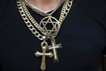 Jewelry with symbols of Christian, Jewish and Rasta religion. Gold chains with cross and star of...