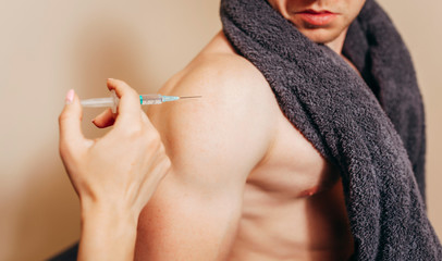 Obraz premium Girl makes bodybuilder injections after workout in locker room