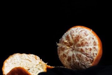 Peeled orange with slices and peel, mystical light