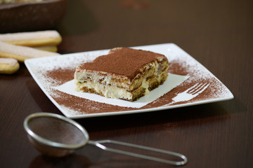 Delicious Tiramisu cake on white plate