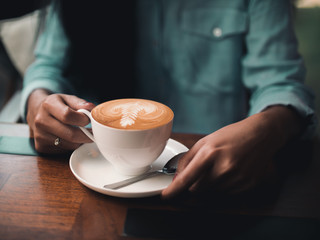 coffee latte art in cafe with woman hand