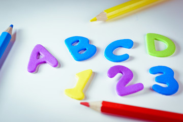 Alphabet letters and numbers over a kid's school desk. Suitable for back to school activities , The first day of classes, office or end of vacations or Kids concepts.
