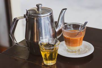 Thai tradition hot tea with sweetened condensed milk in old style cup (Selective focus)