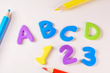 Naklejka premium Alphabet letters and numbers over a kid's school desk. Suitable for back to school activities , The first day of classes, office or end of vacations or Kids concepts.