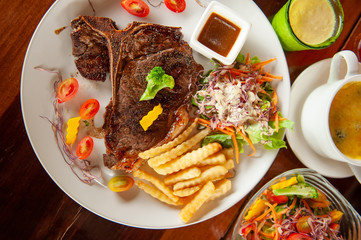 Medium rare Grilled T-Bone Steak with salad.