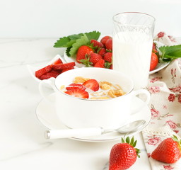 Healthy corn flakes with milk and strawberries for breakfast on marble background, desk, table.Top view. Copy space