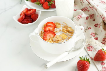 Healthy corn flakes with milk and strawberries for breakfast on marble background, desk, table.Top view. Copy space