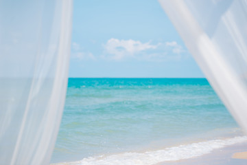 Wind blow white curtains on sand sea,summer holiday concept.