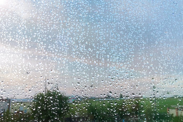 Rain outside window raindrops on windowpane in summer day