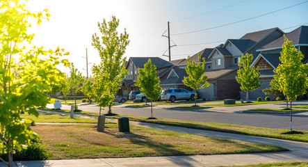 View of modern residential houses neighborhood street in Bentonville, Northwest Arkansas, sunny flare day, fast growing city lifestyle