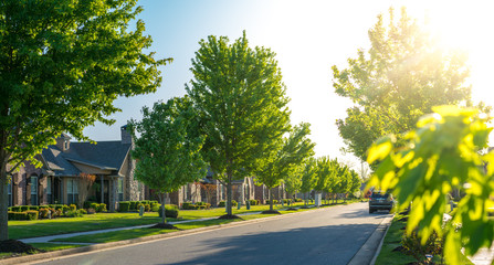 View of modern residential houses neighborhood street in Bentonville, Northwest Arkansas, sunny flare day, fast growing city lifestyle