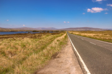 road to nowhere with blue sky and mountains in the background