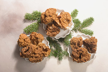 Morels mushrooms and fir-tree branches arranged on light background.