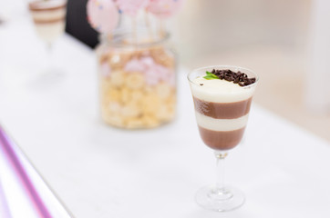 Layered chocolate pudding with yogurt decorated with chocolate crumb and in a glass at the bar counter. space for text. Closeup view.