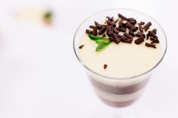 Layered chocolate pudding with yogurt decorated with chocolate crumb and in a glass at the bar counter. space for text. Closeup view.
