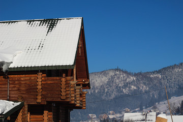 Fresh morning in the snowy mountains at a ski resort. Snow-covered wooden houses