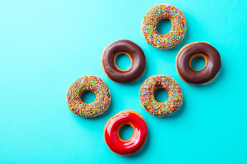 Assortment of donuts on blue background. Copy space. Top view.