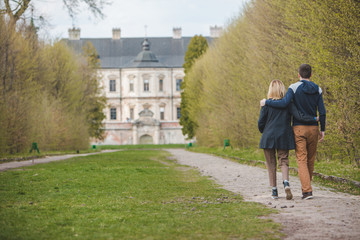 couple walking by alley in front of old beauty castle