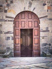 Ancient wooden portal with stone arch of an Italian medieval fortress.