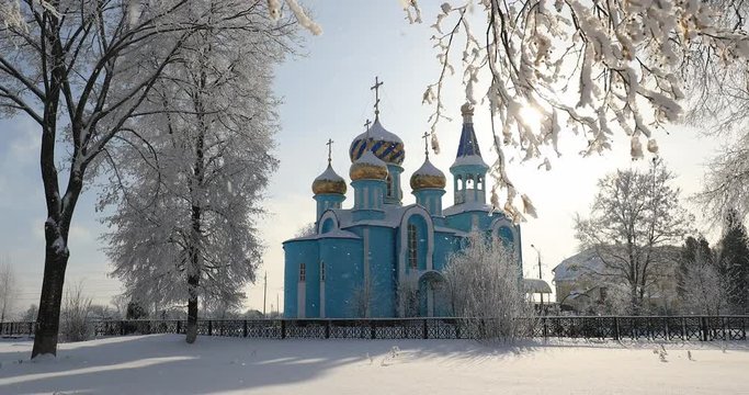 Village Krasnoe, Gomel Region, Belarus. Old Orthodox Church Of The Assumption At Sunny Winter Snowy Day. Famous Landmark Under Snowfall In Snowy Park