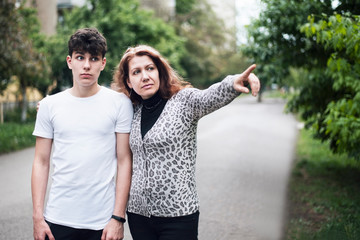 Obraz premium A woman with her son stopped at a walk and looked at something carefully, the woman showed something with her hand
