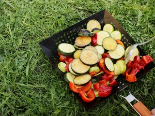 Frying pan with slice of vegetables on green grass